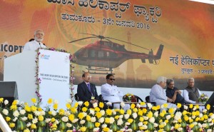 The Prime Minister, Narendra Modi addressing at the foundation stone laying ceremony for HAL Helicopter Factory, at Tumakuru, Karnataka on January 03, 2016. The Governor of Karnataka, Shri Vajubhai Rudabhai Vala, the Union Minister for Defence, Manohar Parrikar and other dignitaries are also seen.